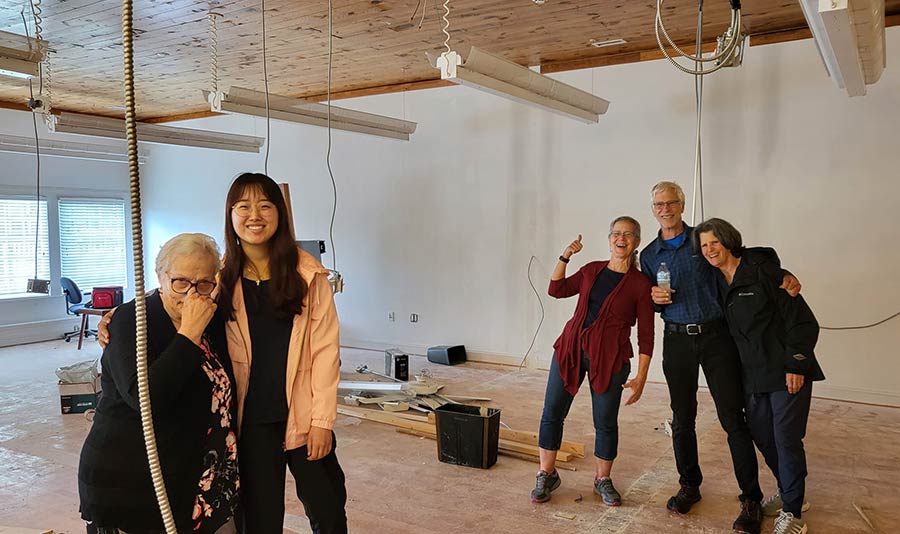 Photo of a building interior being renovated and smiling people