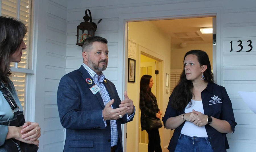 Photo of people talking on the front porch of the Snow Approach Foundation building