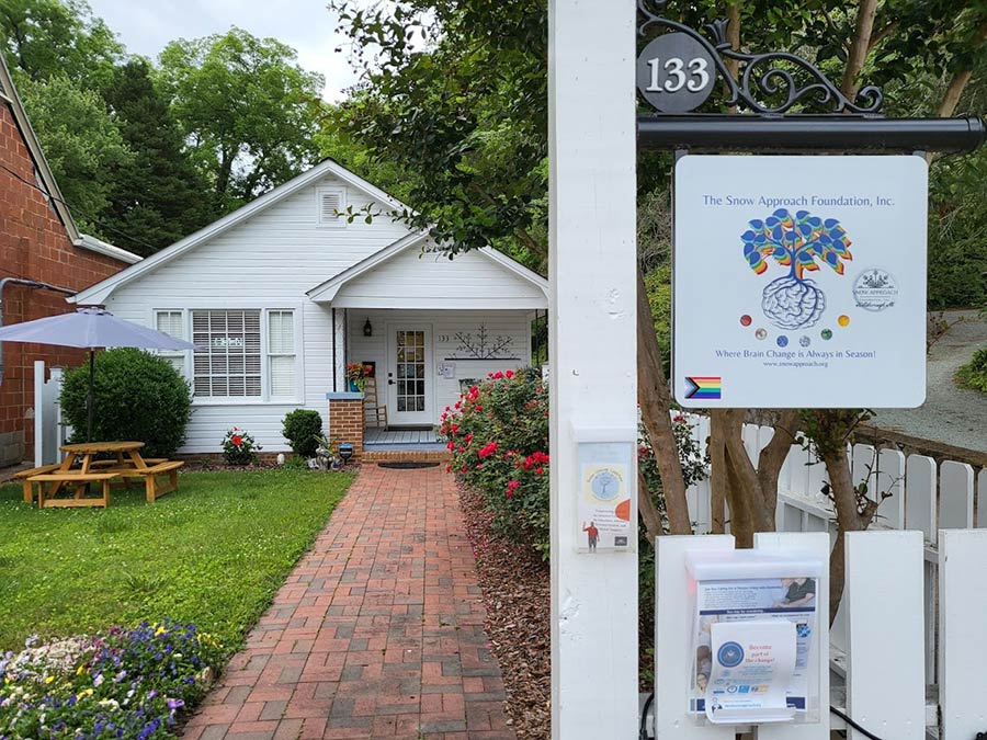 Photo of a little white house with a picket fence