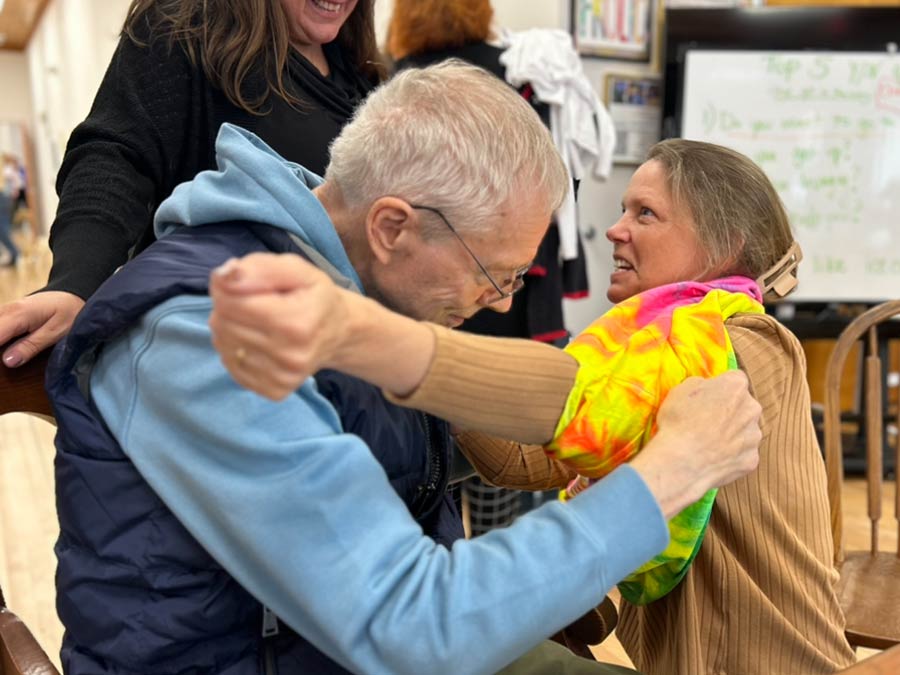 Photo of a man helping a woman put on a shirt