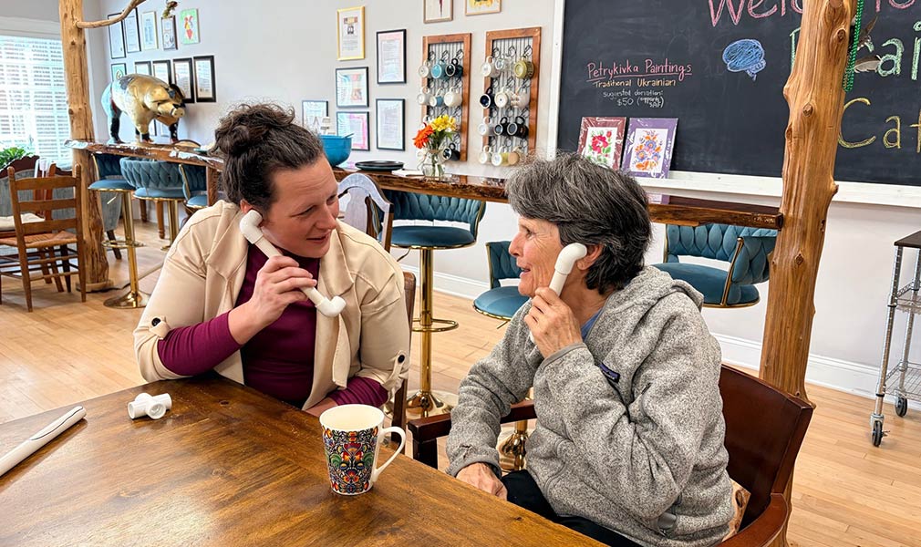 Photo of Amanda chatting with a woman at the Snow Approach Foundation